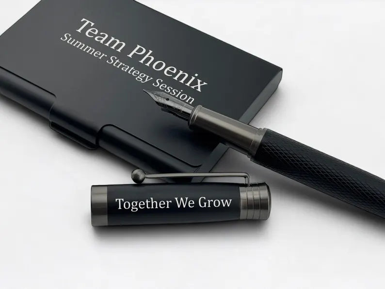 Black personalized pen and presentation box with an engraved team message.