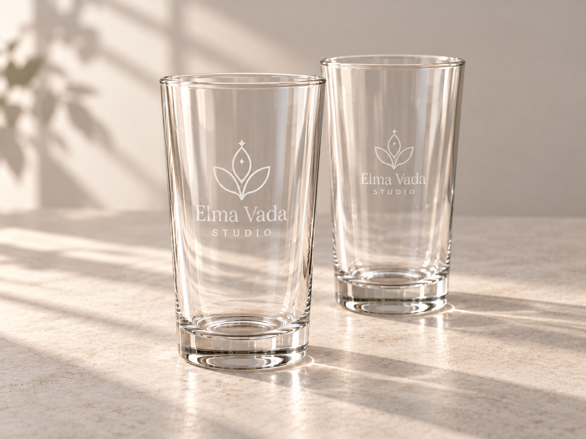 Two clear drinking glasses with frosted Elma Vada Studio lettering and a leaf motif.