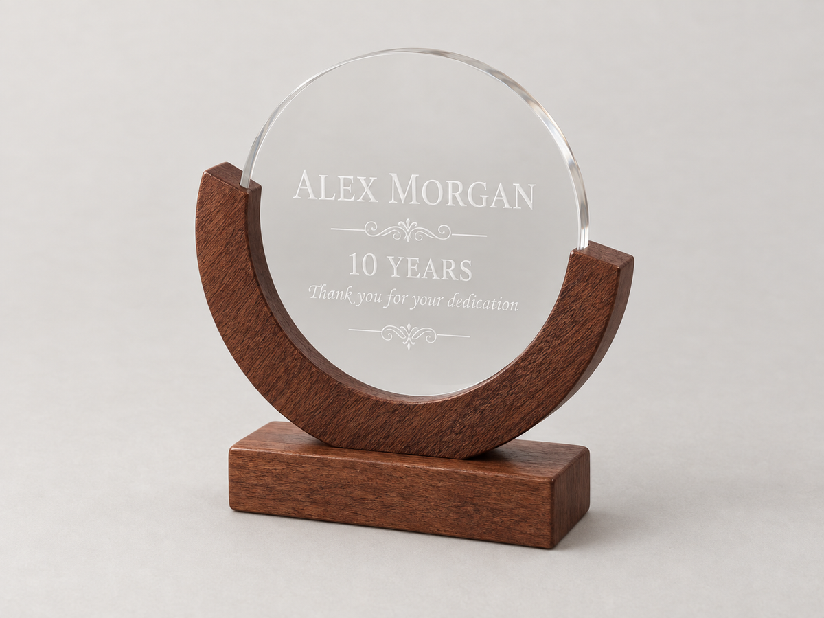 Clear circular award on a wooden base engraved with Alex Morgan and 10 Years.  DFW