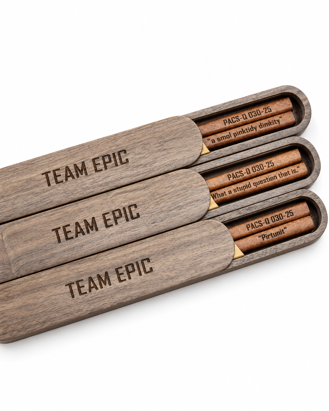 Three wooden pen cases engraved with the same team name, each holding a personalized wooden pen.