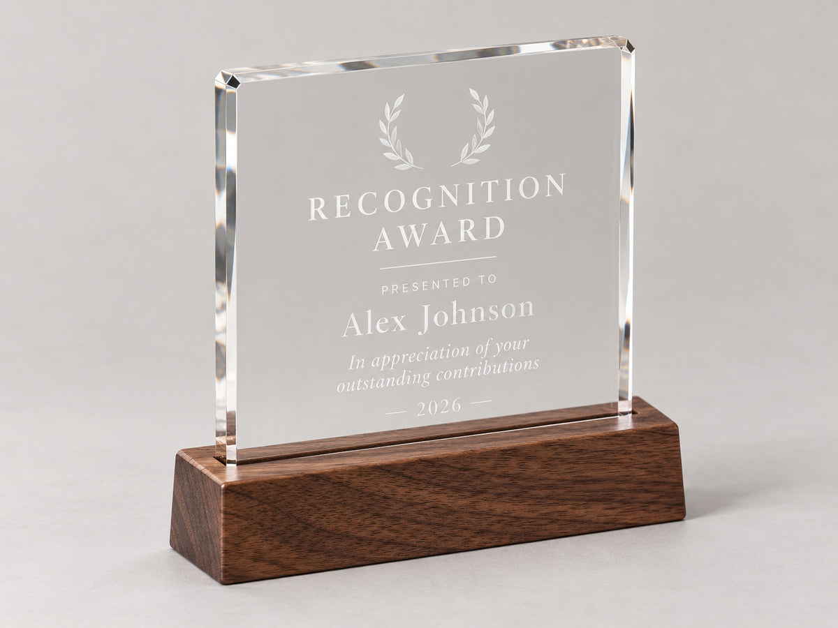 Clear personalized recognition award engraved with a recipient name and appreciation message on a dark wooden base.
